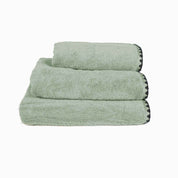 Serviette de bain Issey Haomy en coton 550 g/m², coloris céladon, finition overlock noir, disponible en 3 tailles – douce et absorbante