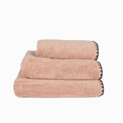 Serviette de bain Issey Haomy en coton 550 g/m², coloris cimarron, finition overlock noir, disponible en 3 tailles – douce et absorbante