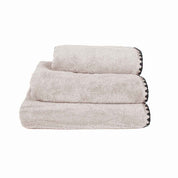 Serviette de bain Issey Haomy en coton 550 g/m², coloris lin, finition overlock noir, disponible en 3 tailles – douce et absorbante